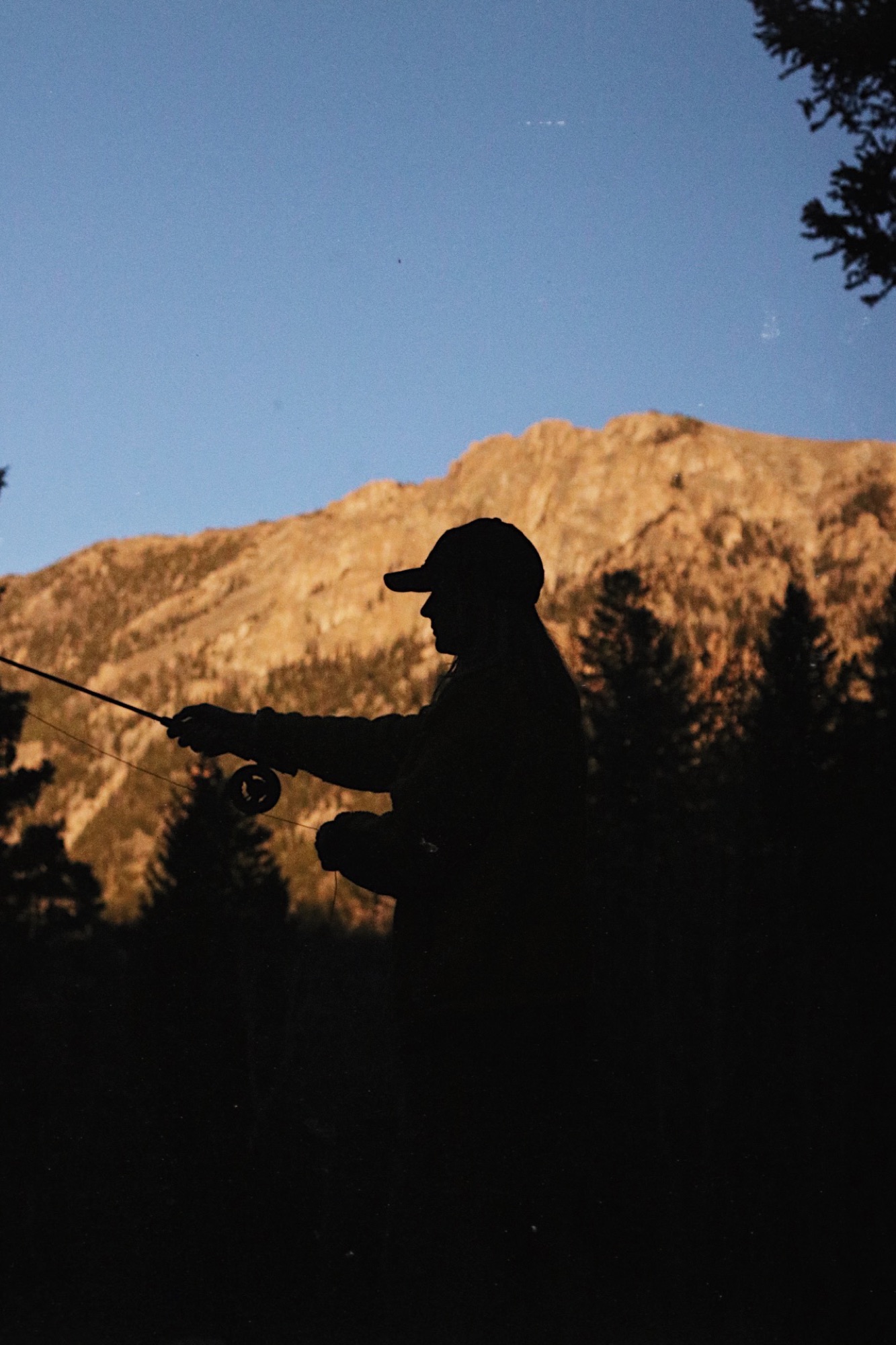 A guest fly fishing at sunset at a Refuge property